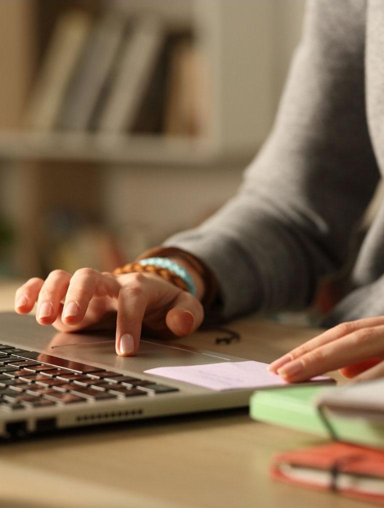 student-hands-using-touchpad-on-laptop